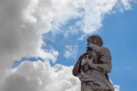 contrast between clouds and statue