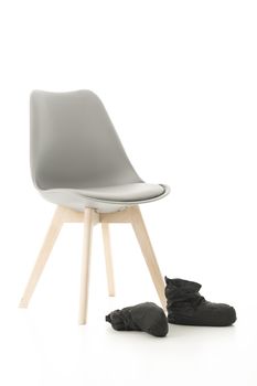 Conceptual Wooden Leg Chair and Black Boots Isolated on White Background.