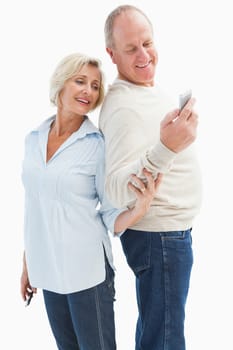 Happy mature couple looking at smartphone together on white background