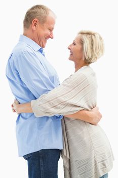 Happy mature couple hugging and smiling on white background