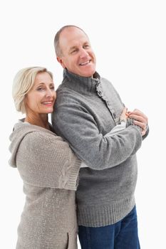 Happy mature couple in winter clothes on white background