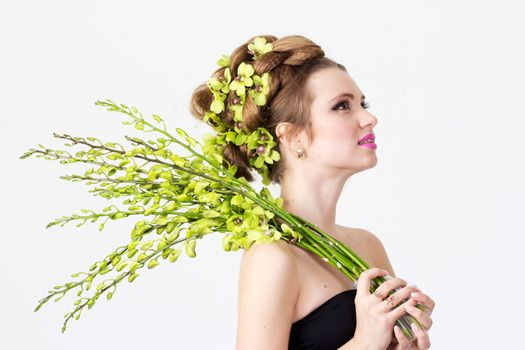 Beautiful woman with orchid flower in hair posing