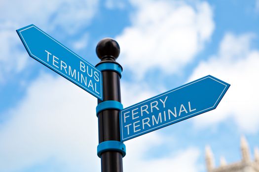 Blue bus and ferry terminal sign in front of a clouded blue sky.