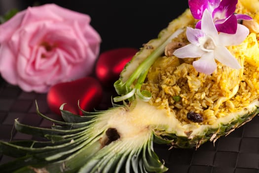 Freshly prepared pineapple fried rice served inside of a pineapple carved like a bowl.