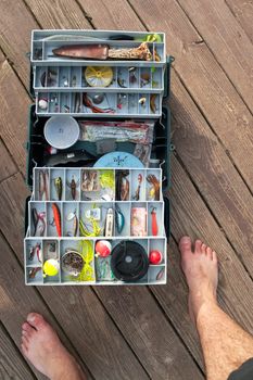 A large fishermans tackle box fully stocked with lures and gear for fishing.