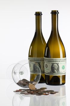 Empty bottles of wine from the label of dollar bill on a glass table