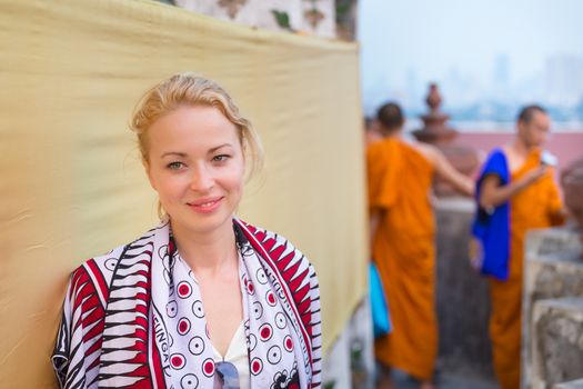 Caucasian, Blonde, Female Traveler Visiting Buddhist Temple of Wat Arun in Bangkok, Thailand.