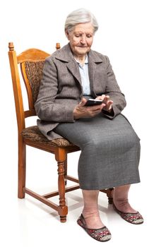 Senior woman using mobile phone while sitting on chair