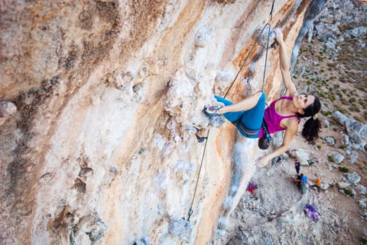 Young female rock climber on a cliff face