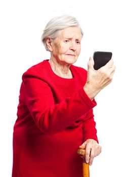 Upset elderly woman using touch screen mobile for taking selfie or making video call