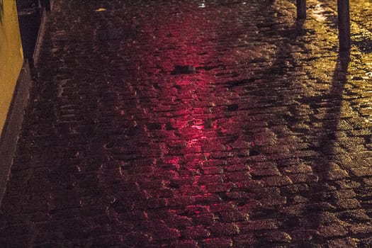 Close-up pedestrian street in the night, with orange and red light