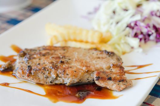 Grilled steaks, french fries  and vegetable salad
