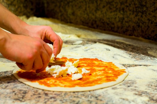 Spread cheese in the pizza whit tomato sauce