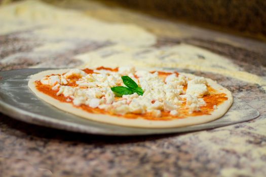 machining of the pizza. Italian pizza chef puts on the blade pizza and bake