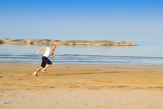 boy who trains running on the beach