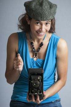 Retro style young girl photographer ready to click the remote shutter release to capture an image.