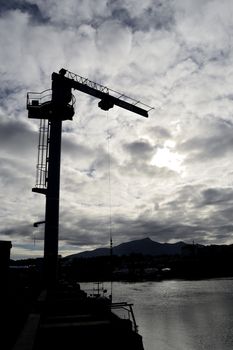 silhouette of a crane in a harbor, Saint Jean de Luz, France