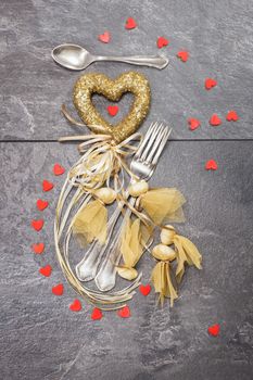 Valentines dinner table setting in romantic style with bonbons and hearts. Copy space for your text