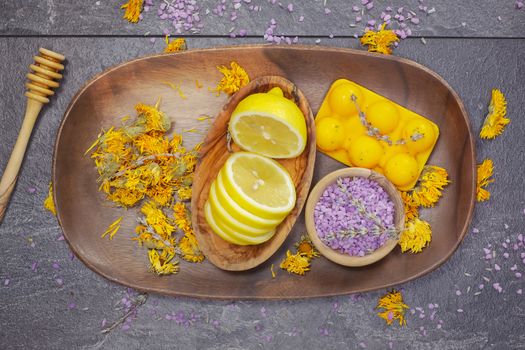 Natural beauty care, lemon, lavender and marigold or Calendula. Various objects and beauty products on the wooden board.