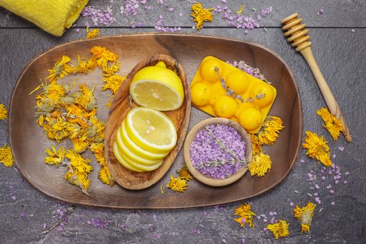 Natural beauty care, lemon, lavender and marigold or Calendula. Various objects and beauty products on the wooden board.