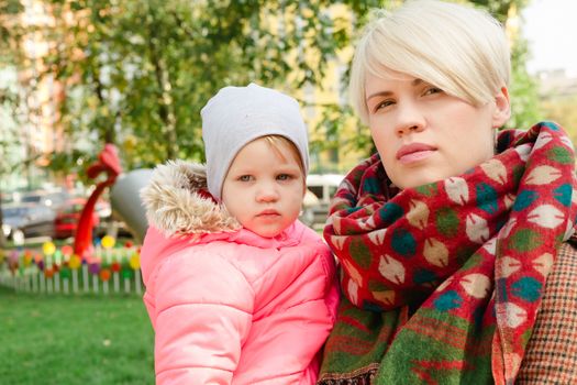 Beautiful Mother And Baby outdoors. Nature. Beauty Mum and her Child playing in Park together. Outdoor Portrait of happy family. Joy. Mom and Baby