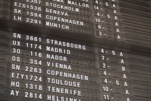 Airport departure board in terminal with flight information