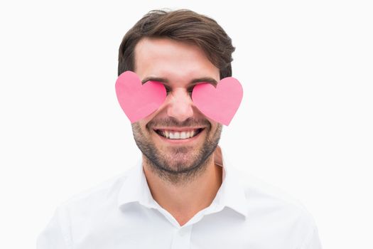 Handsome man with hearts over his eyes on white background