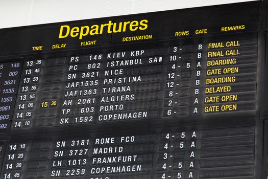 Airport departure board in terminal with flight information