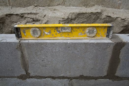 Yellow spirit level on a constructed wall outdoors