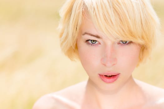 Portrait of  beautiful young Caucasian woman outdoor in the meadow on a sunny summer day.