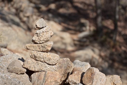 Stone cairn on a blurry background in a sunny day