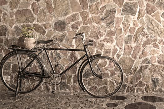 Vintage bicycle leaning against stone brick wall