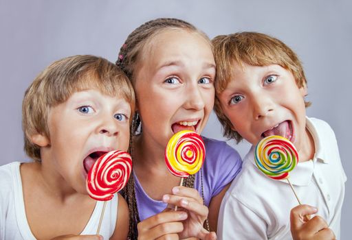 Group of happy children eating candy