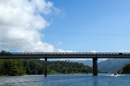 bridge across river with mountain blue sky