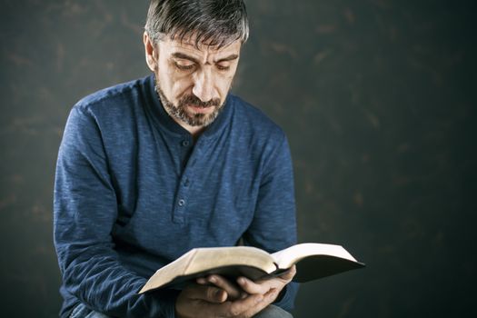 Man reading from the holy bible, close up