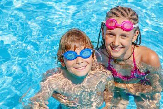 Kids playing around in swimming pool.