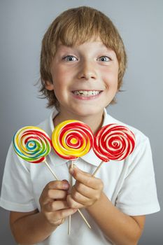 child boy eating lollipop isolated