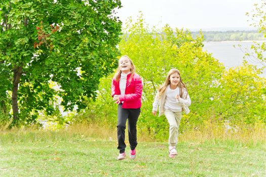 Photo of two running girls in summer