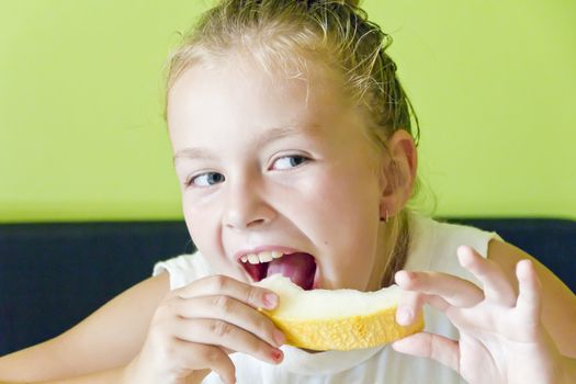 Photo of the cute girl eating melon