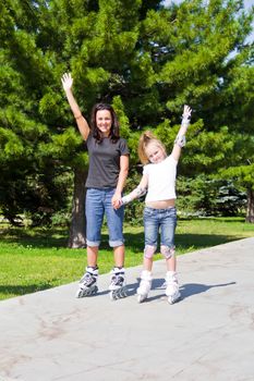 Photo of mother and daughter on roller skates in summer
