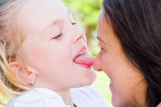 Photo of kissing mother and daughter in summer