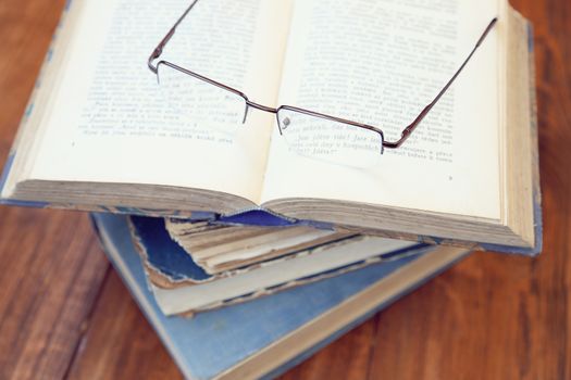 glasses lie on a few opened age-old books