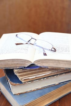 glasses lie on a few opened age-old books