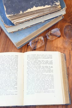 glasses and a few opened age-old books