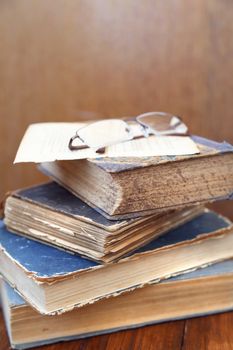 glasses lie on a few closed age-old books