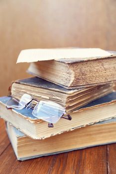 glasses lie on a few closed age-old books