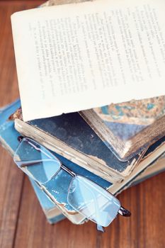 glasses lie on a few closed age-old books