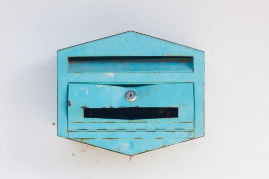 a green broken mailbox on a wall in Thailand