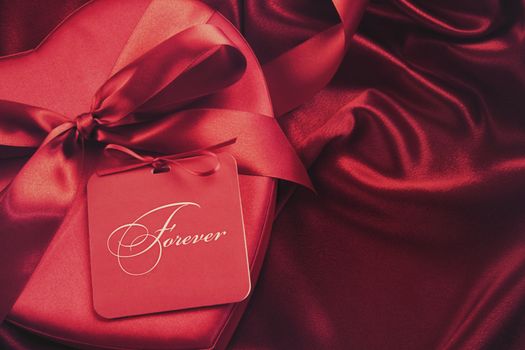 Closeup of chocolate box with gift card on satin background