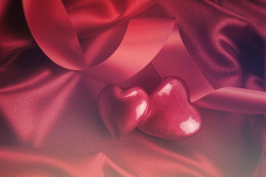 Red hearts on satin background